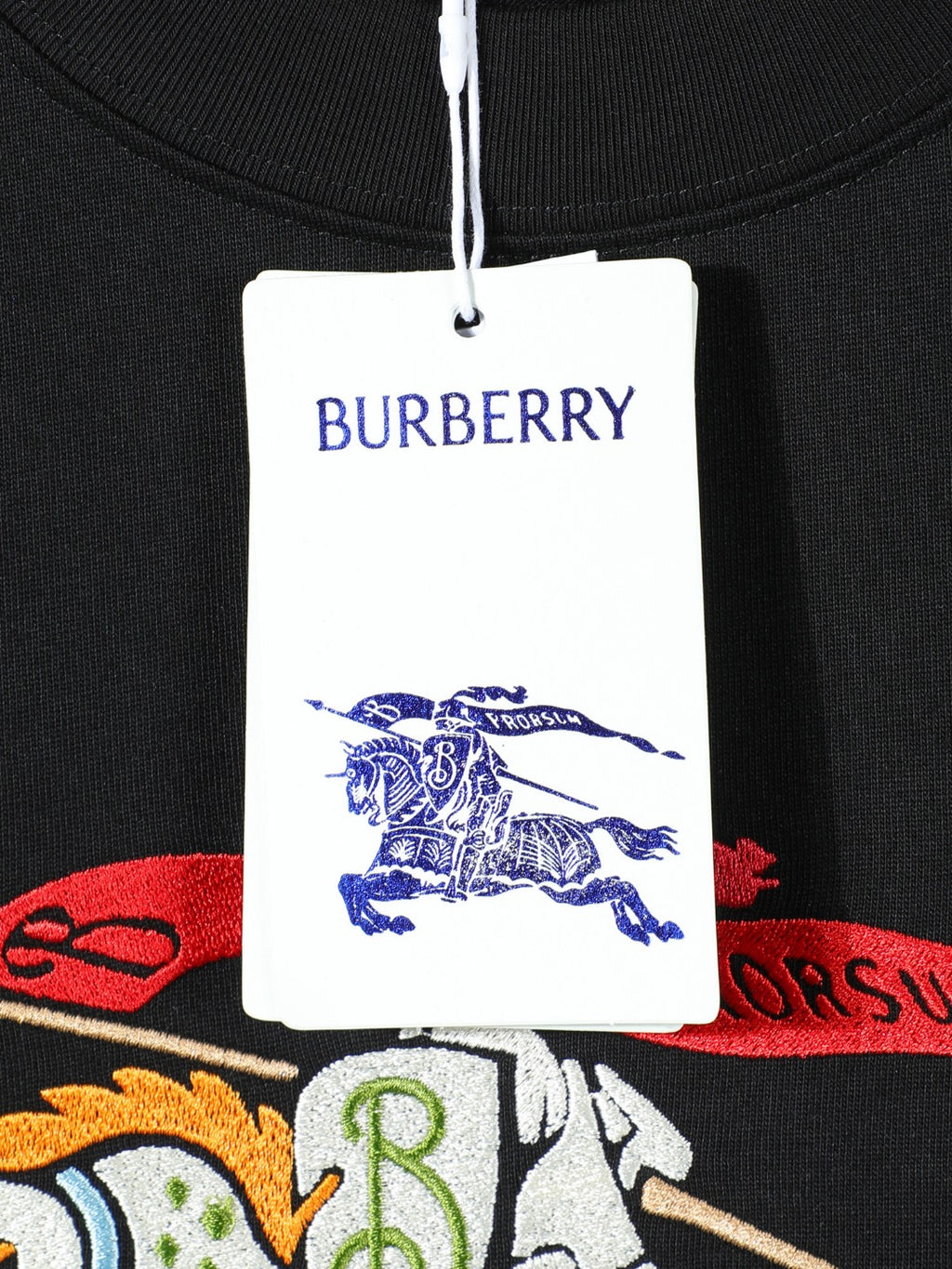 Black T-shirt tag and neckline with BURBERRY logo and crest graphic.