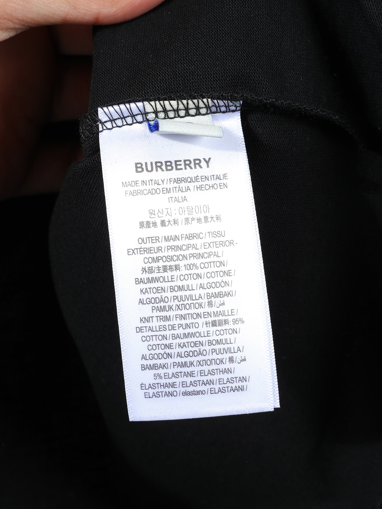 Black T-shirt inner care label with size and fabric composition text.