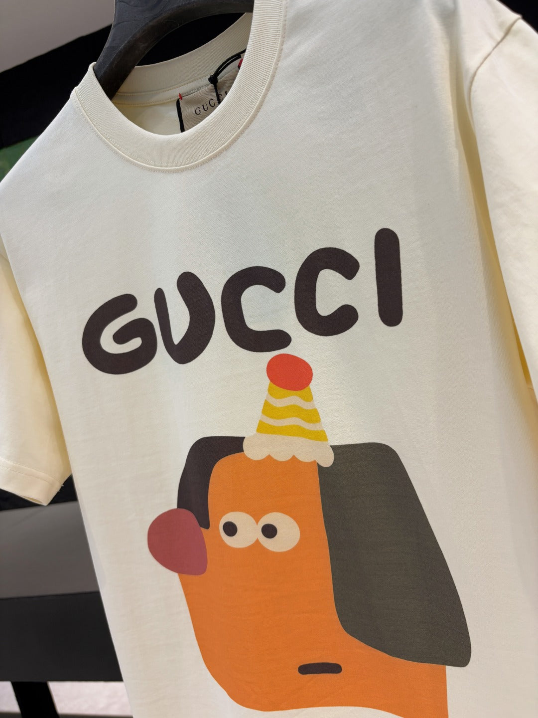 Cream short-sleeve T-shirt close-up of Gucci logo and cartoon graphic