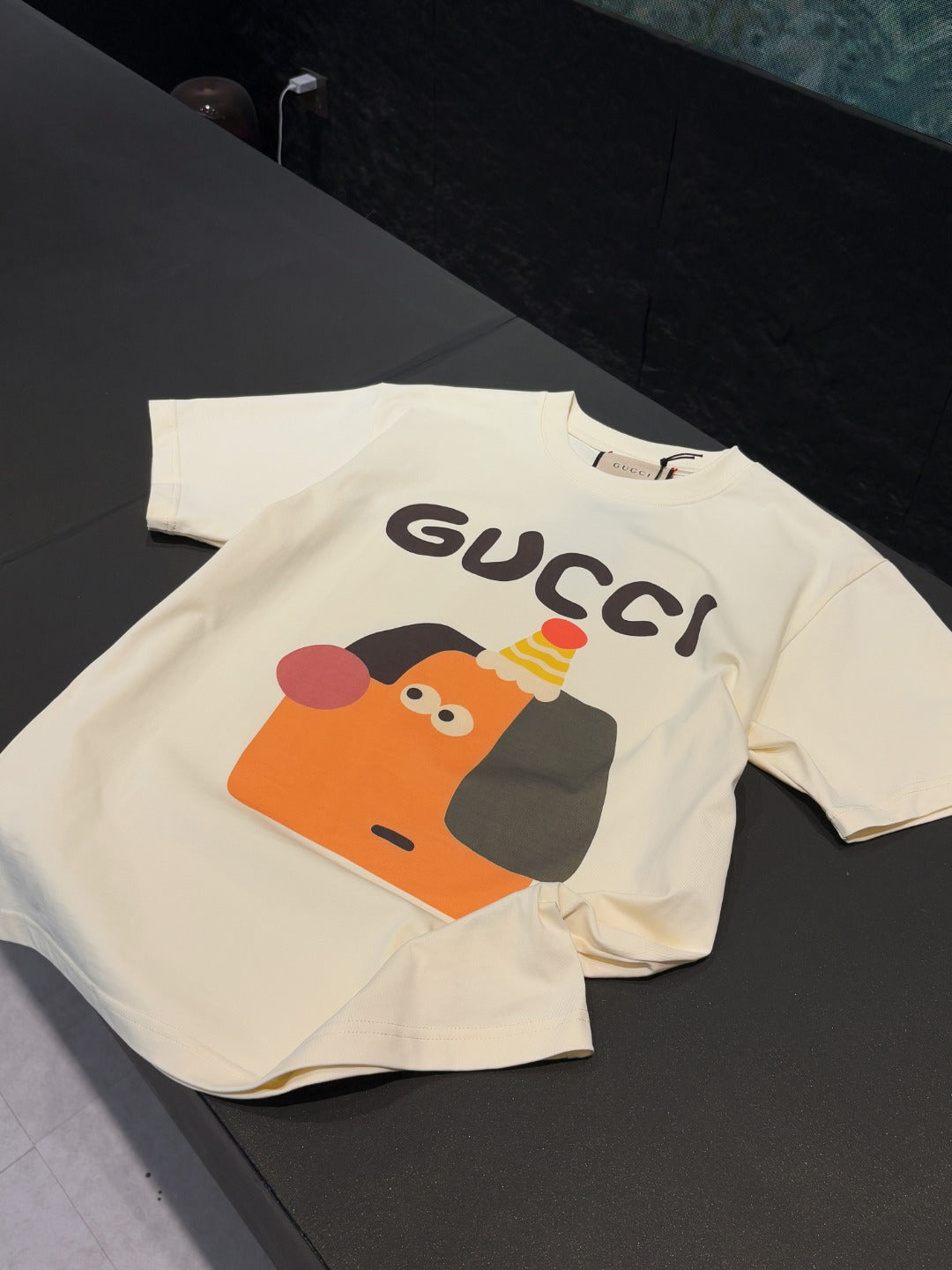 Cream short-sleeve T-shirt folded with Gucci logo and cartoon graphic
