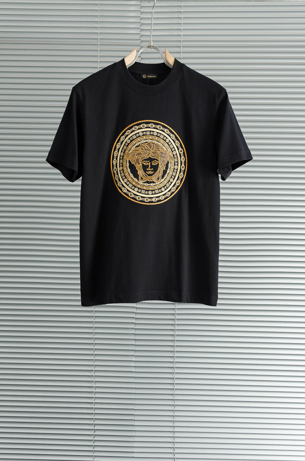 Black T-shirt with gold Versace-style medallion graphic on the chest