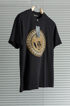 Black T-shirt with large gold medallion graphic at center chest