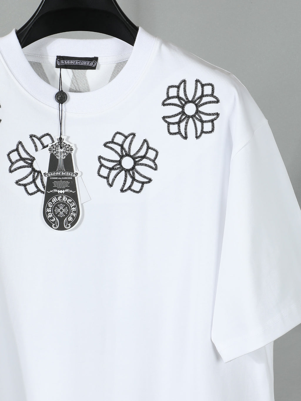White short-sleeve T-shirt close-up of black flower and charm embroidery