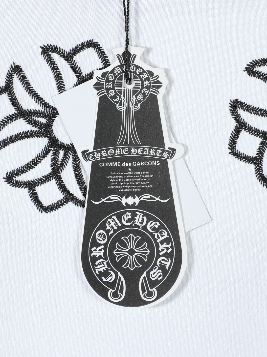 White T-shirt chest logo tag detail with black embroidered crest graphic