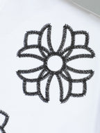 White T-shirt close-up of black embroidered flower appliqué graphic