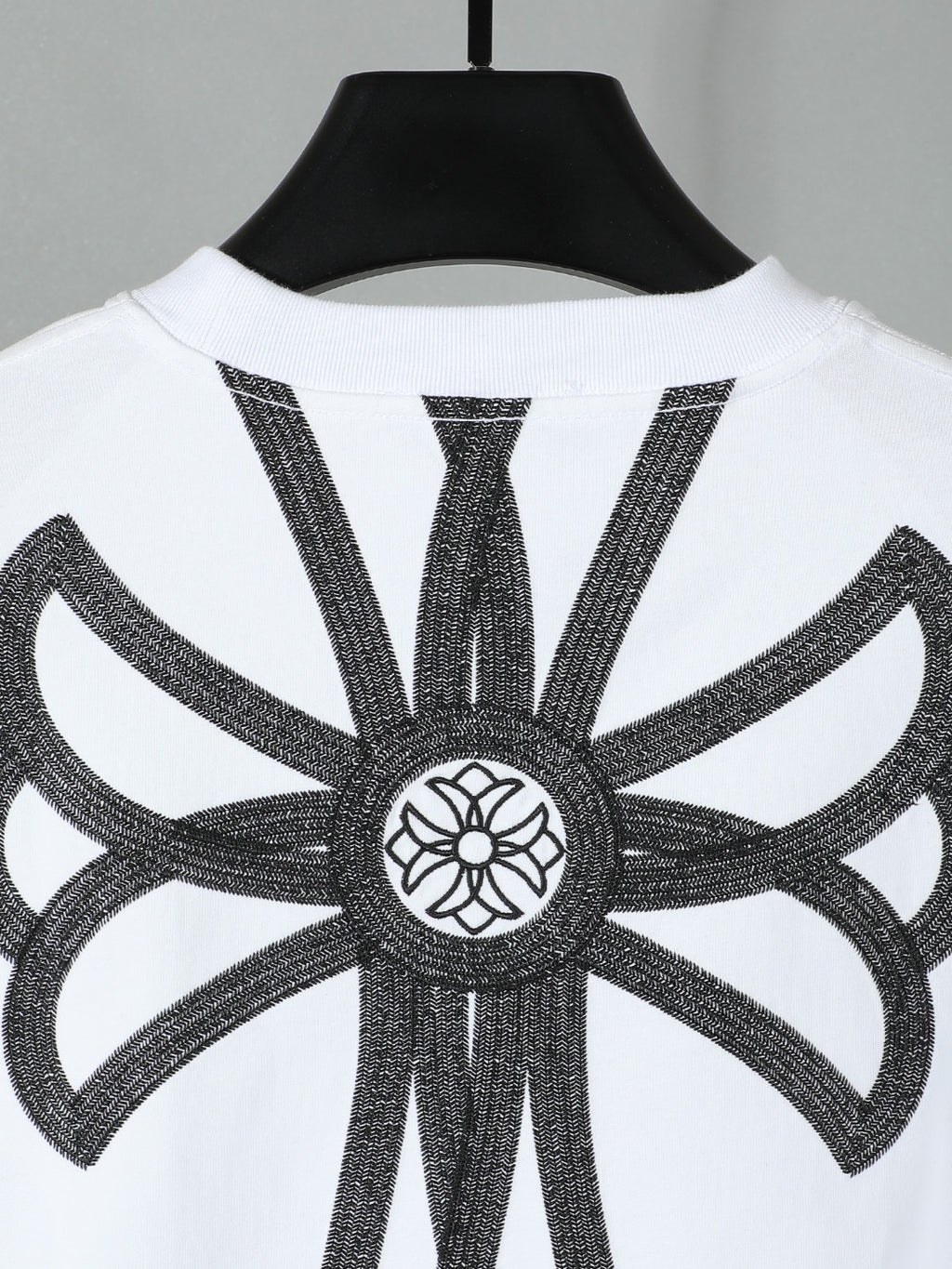 White short-sleeve T-shirt with large black angel-like embroidery graphic on back