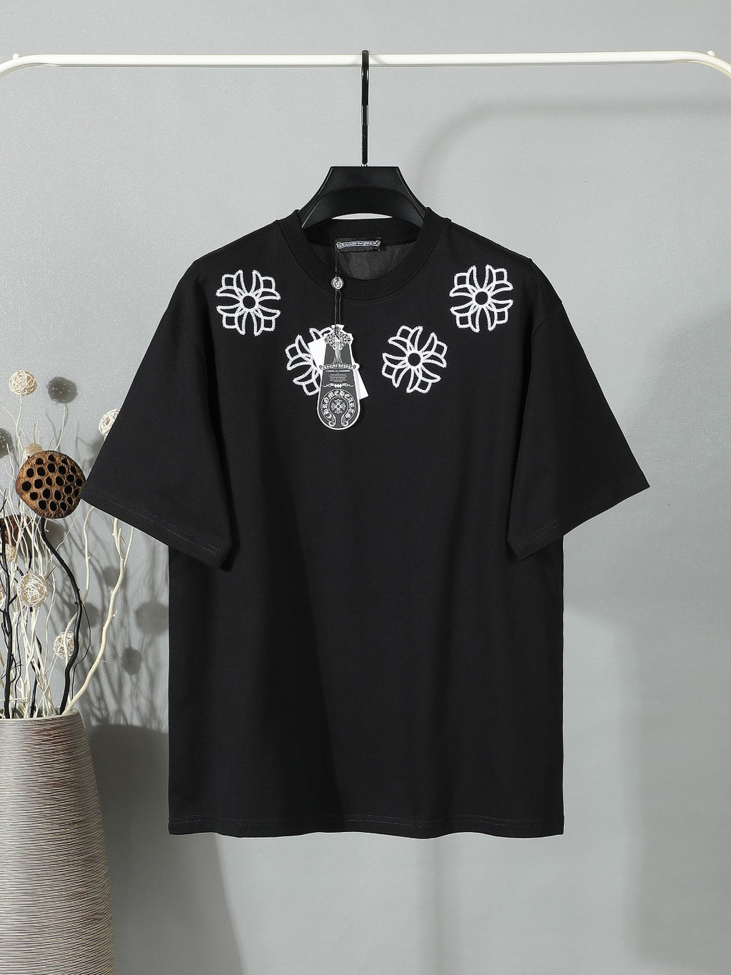 Black short-sleeve T-shirt with white floral crest embroidery on the chest