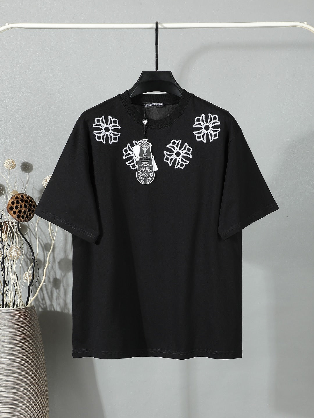 Black short-sleeve T-shirt with white floral crest embroidery on the chest