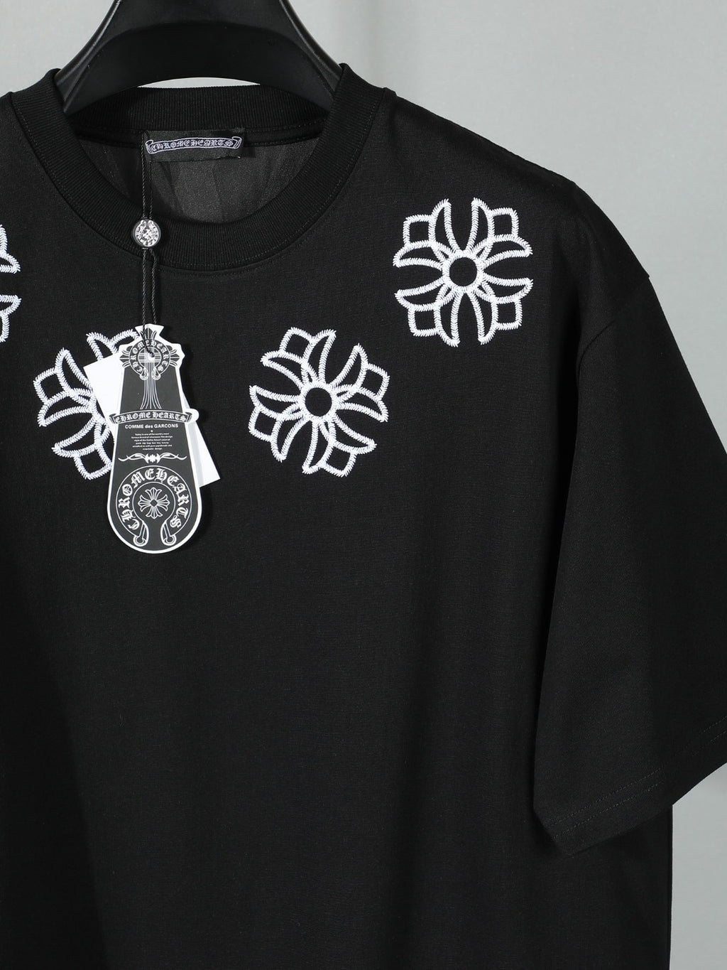 Black short-sleeve T-shirt with white front floral and crest embroidery detail