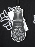 Black T-shirt chest tag artwork print with white cross-like floral motifs