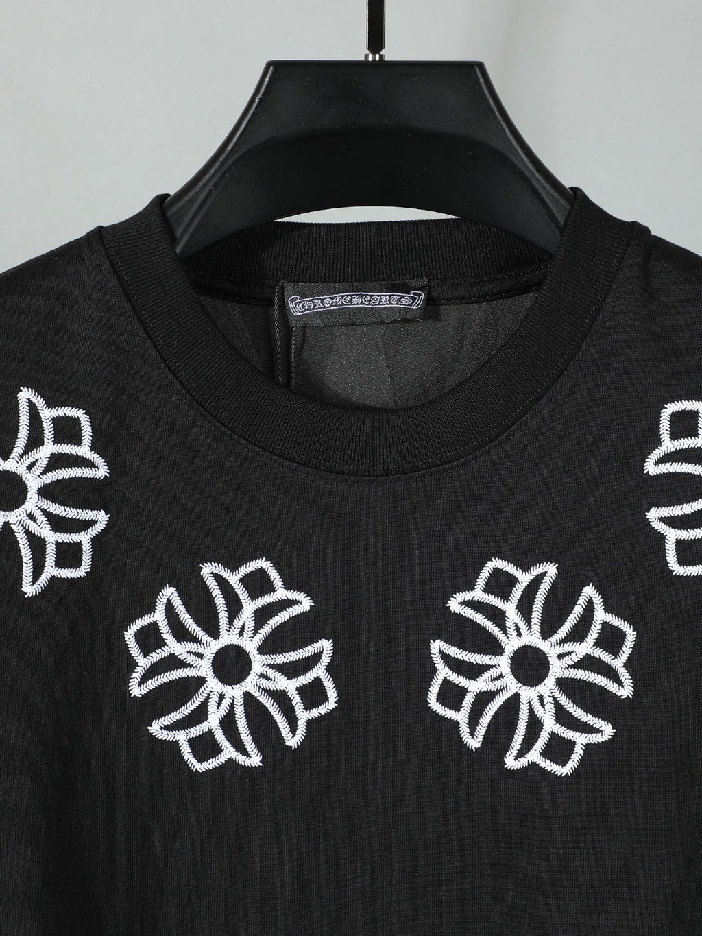 Black short-sleeve T-shirt with scattered white flower embroidery on the front