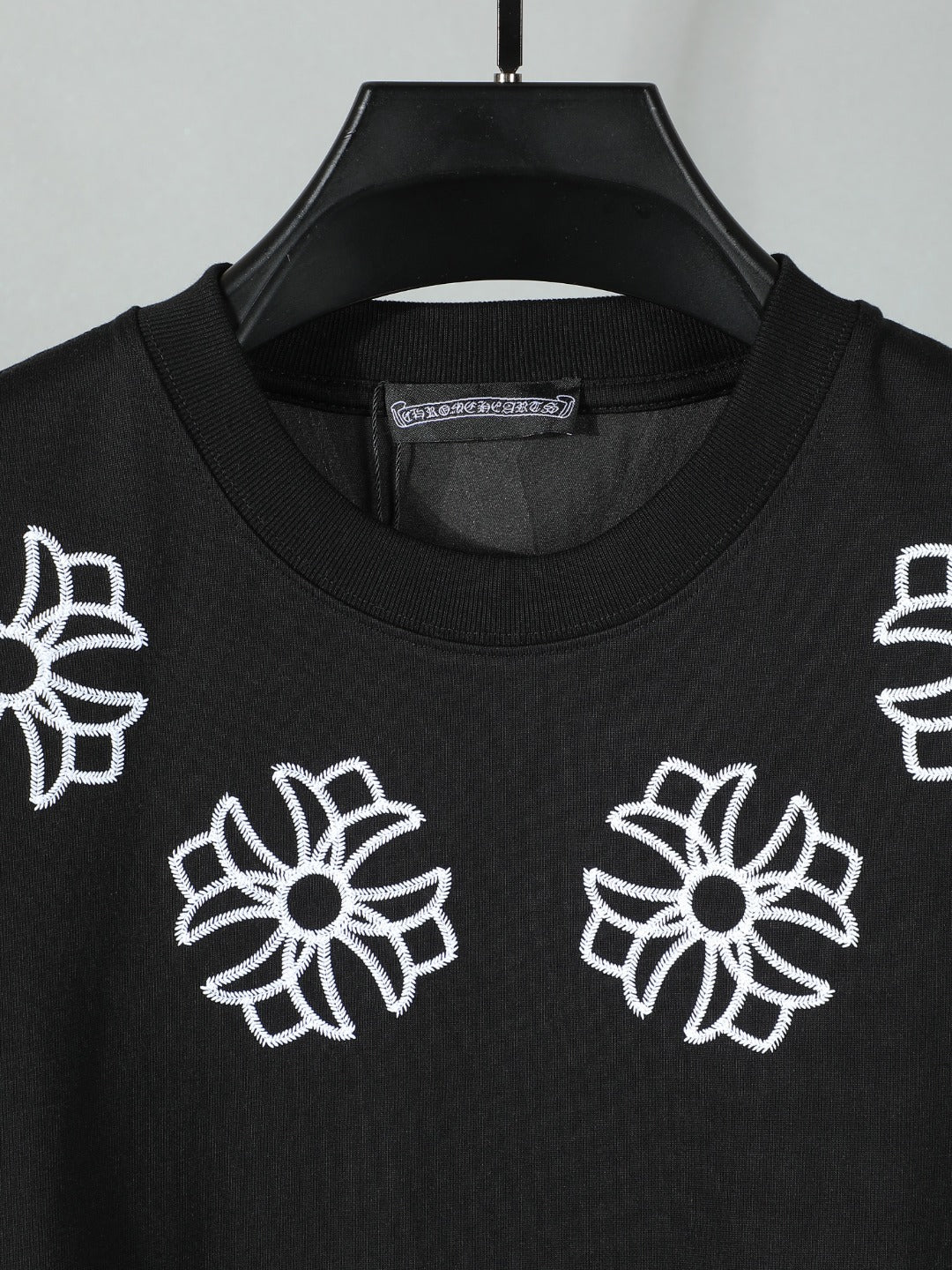 Black short-sleeve T-shirt with scattered white flower embroidery on the front