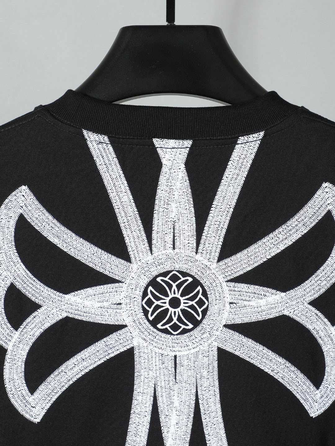 Black short-sleeve T-shirt with large white backburst graphic centered on top