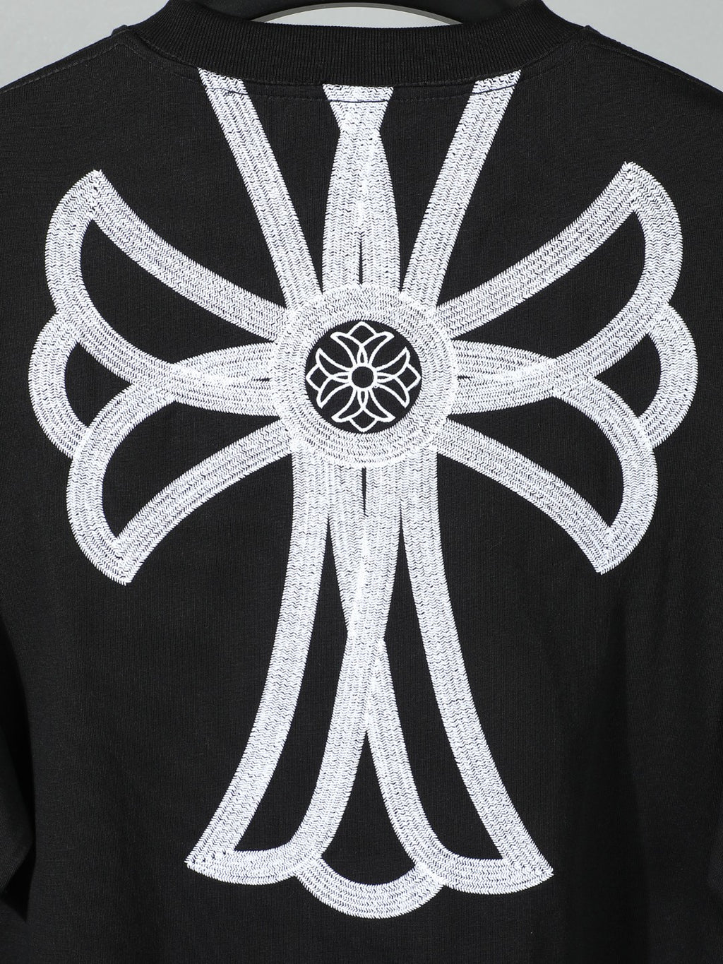 Black short-sleeve T-shirt with oversized white backburst floral emblem