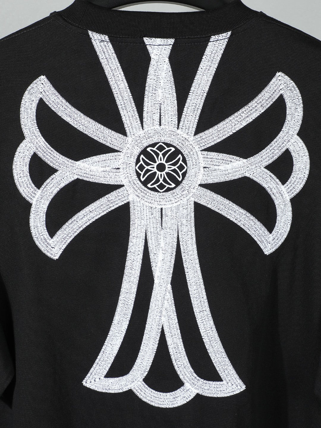 Black short-sleeve T-shirt with oversized white backburst floral emblem
