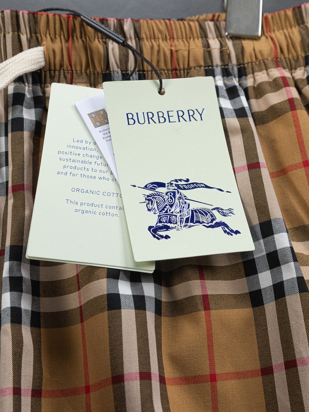 Plaid shorts with Burberry hang tag attached to waistband