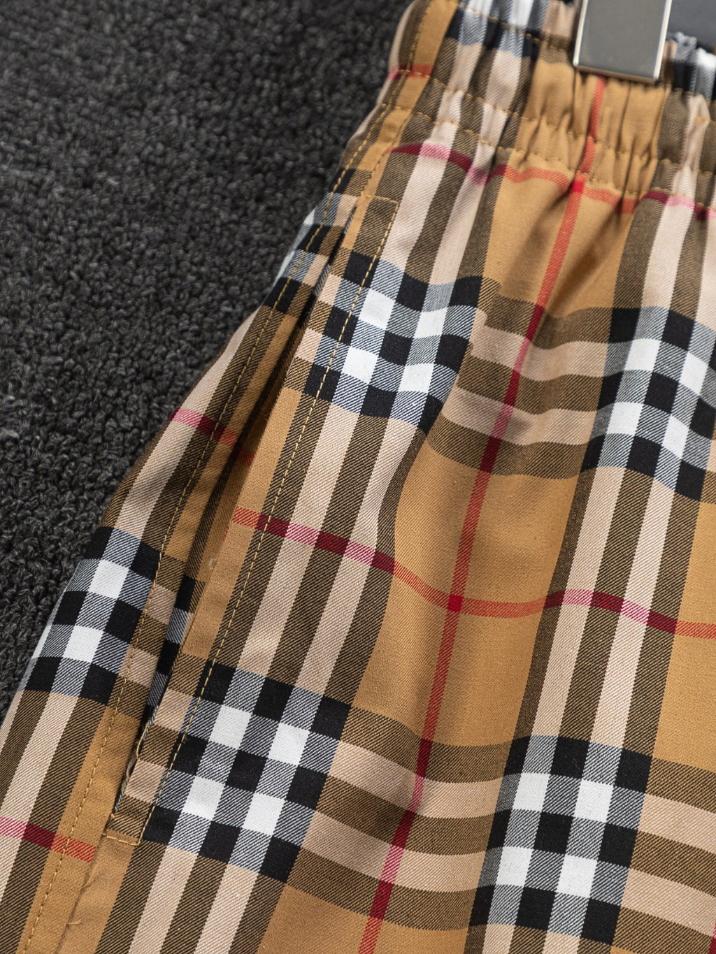 Plaid shorts side view with elastic hem and tan check pattern