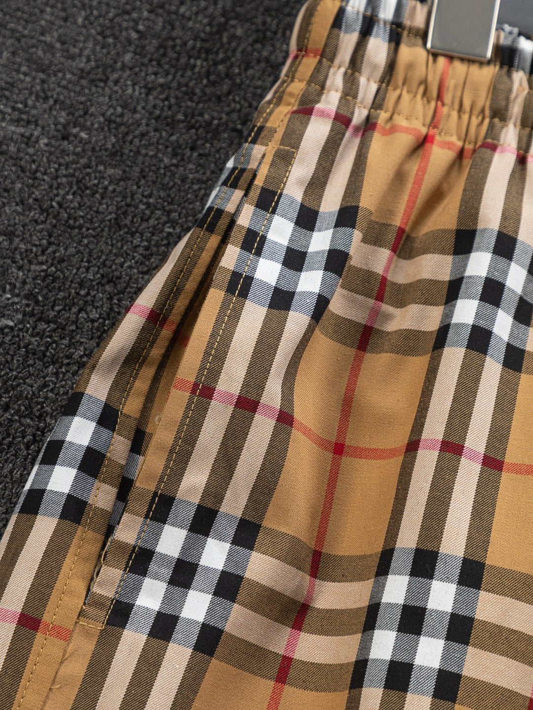 Plaid shorts side view with elastic hem and tan check pattern