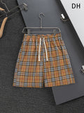 Plaid drawstring shorts with elastic waistband, tan, black, and red check
