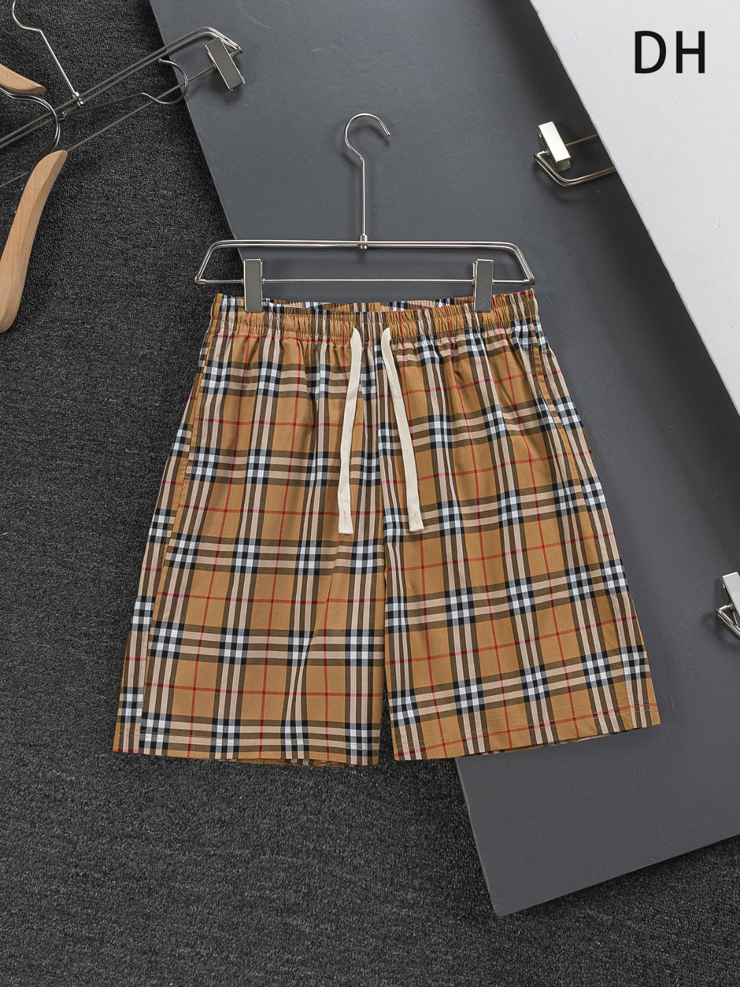 Plaid drawstring shorts with elastic waistband, tan, black, and red check