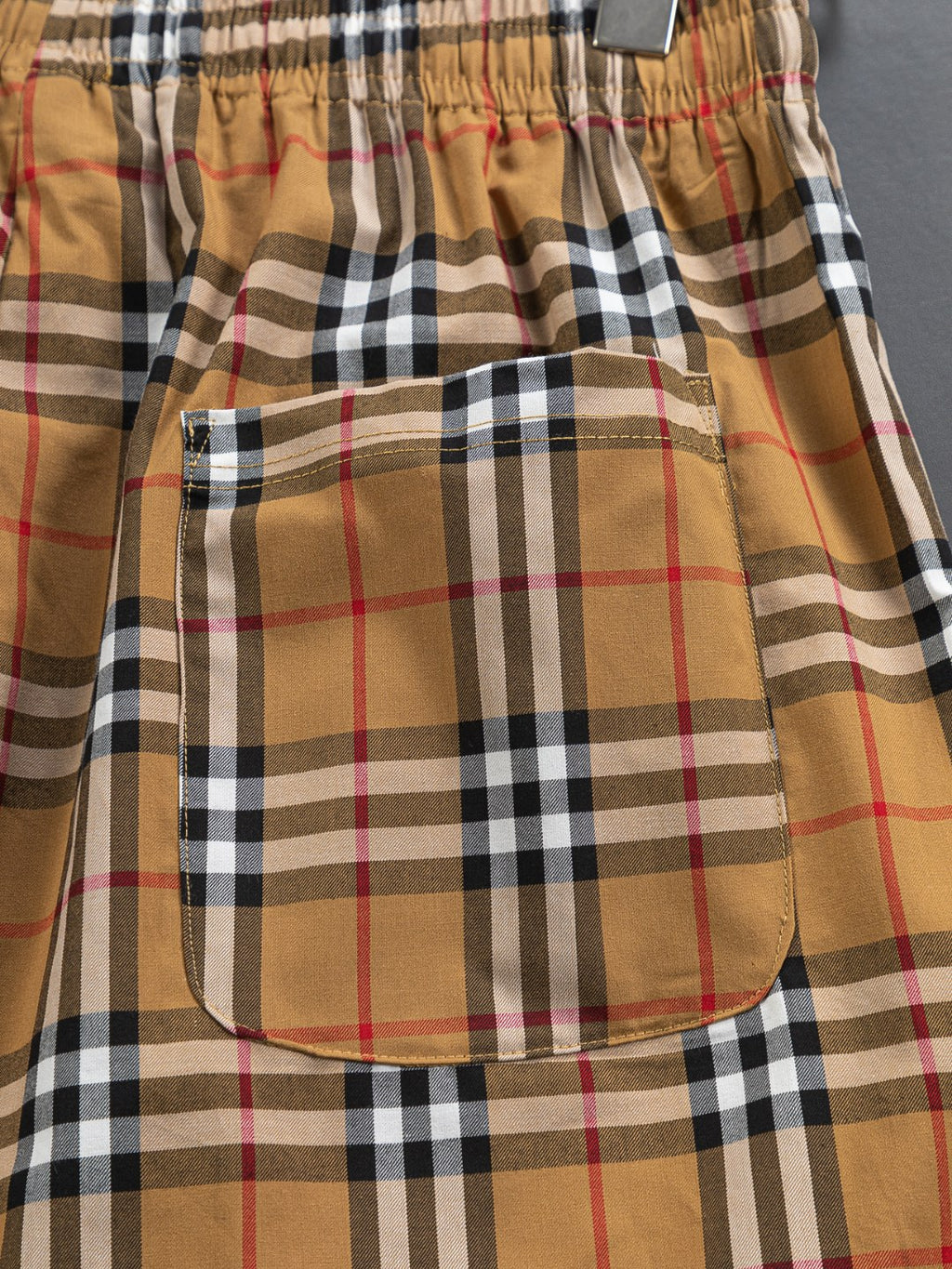 Plaid patch pocket on front of shorts, tan and black check