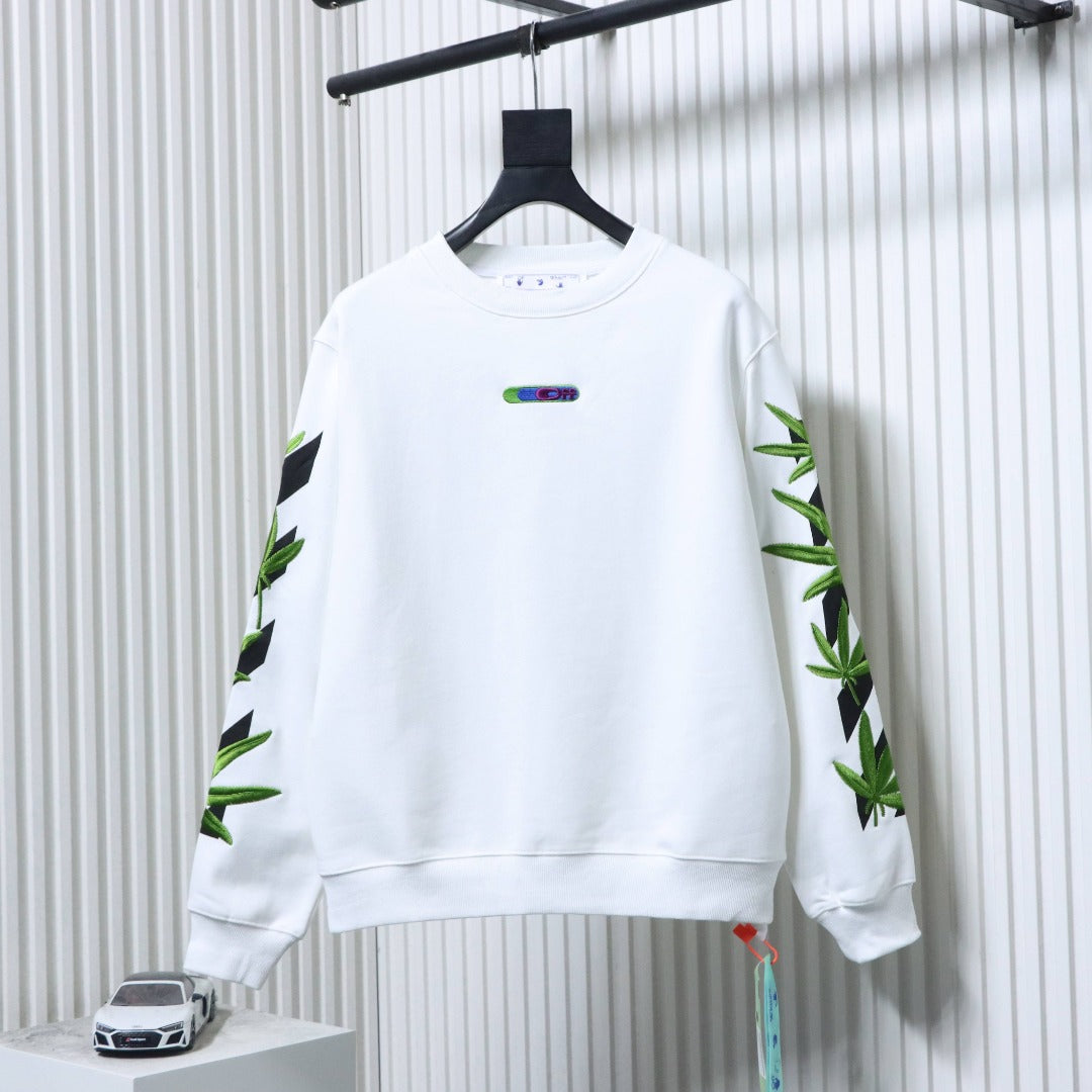 Off-white sweatshirt with green cannabis leaf graphic on sleeves
