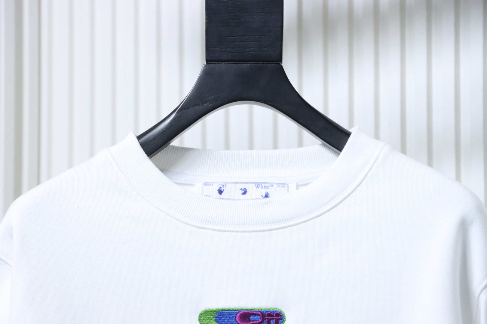 Off-white crewneck sweatshirt neckline with small chest logo patch