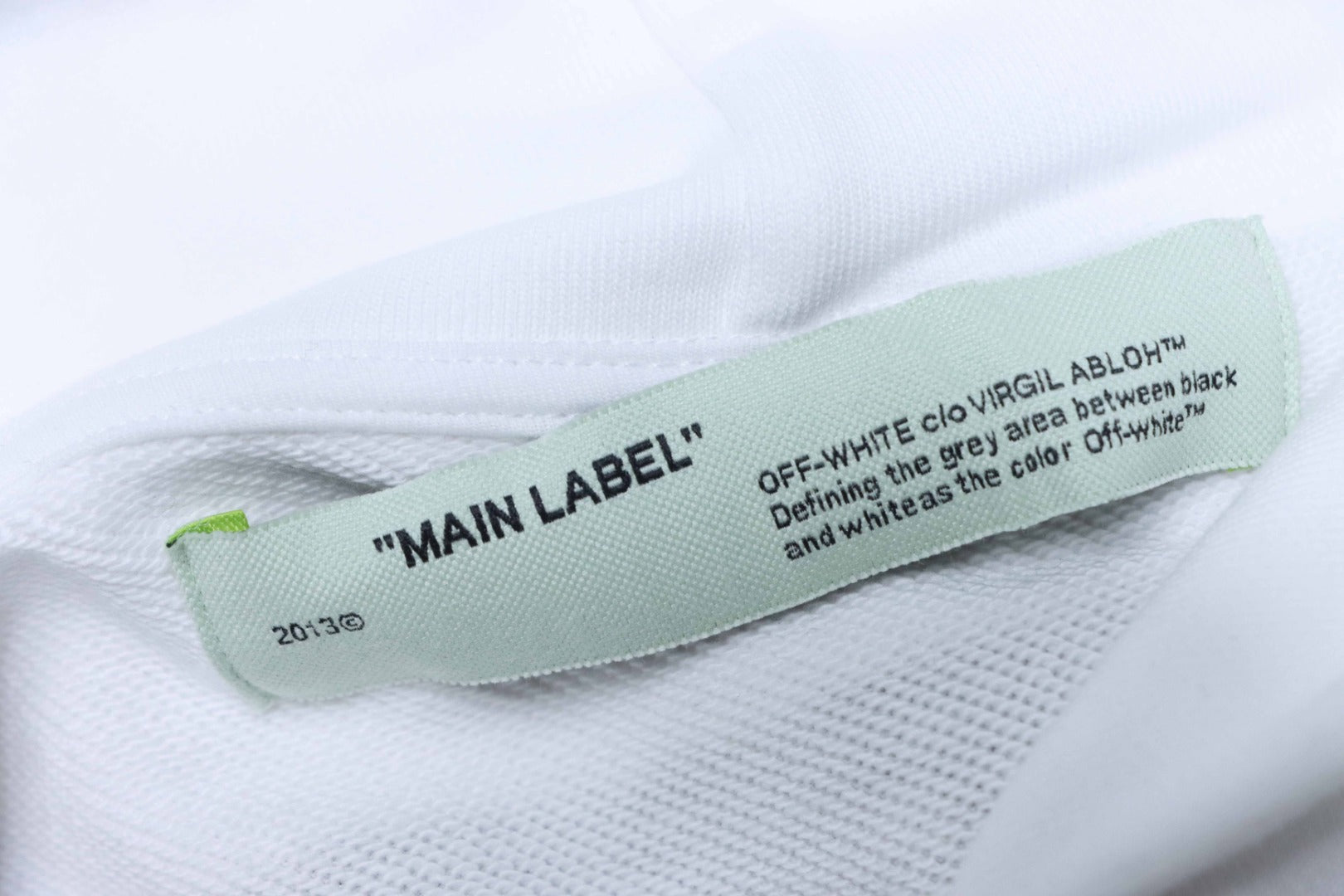 Off White hoodie inner neck label reading 'MAIN LABEL' on green fabric tag