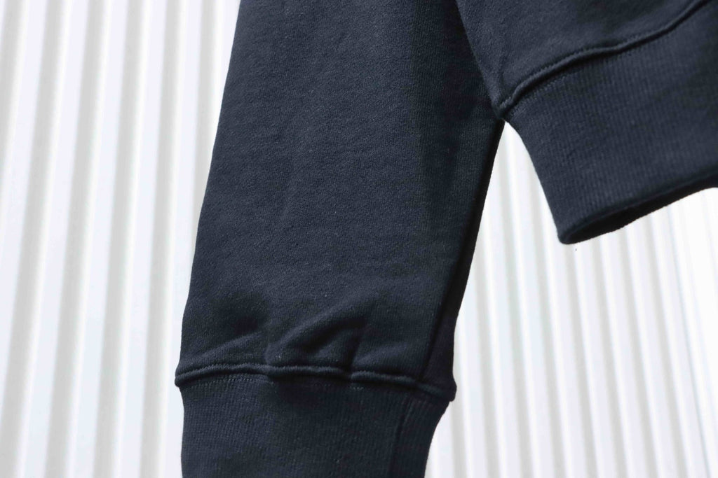 Black hoodie sleeve section with ribbed cuff and curved hem