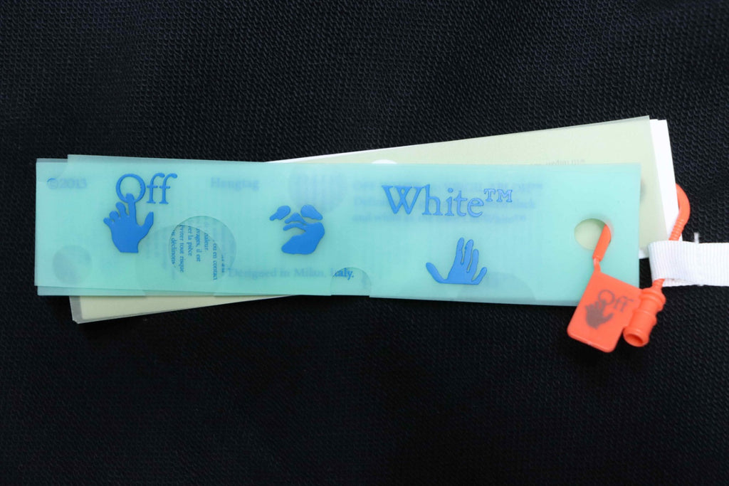Off White hoodie hang tag next to printed fabric care label
