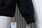Off White hoodie sleeve cuff detail in dark fabric, hanging tag visible