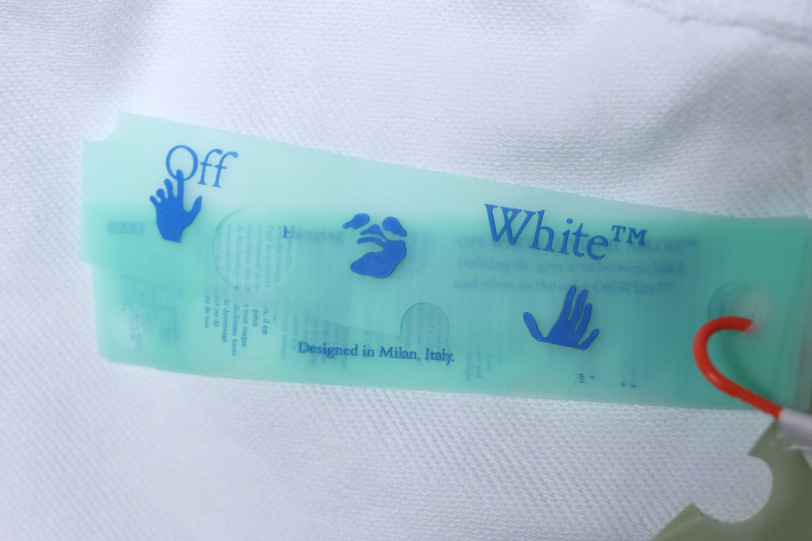 Off-White off-white hoodie inner label on fabric with brand and size text.