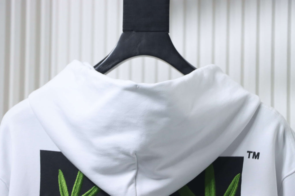 Off-White off-white hoodie close-up of back hood and green leaf print panels.