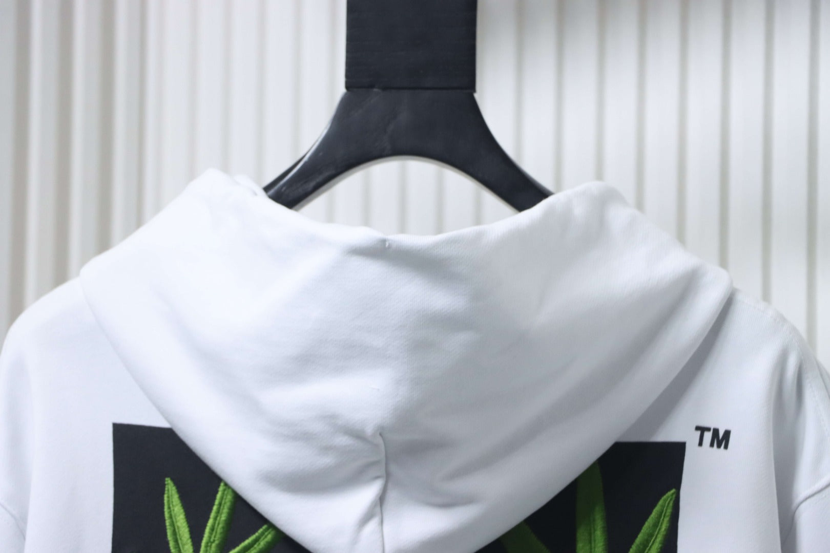 Off-White off-white hoodie close-up of back hood and green leaf print panels.