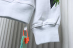 Off-White off-white hoodie cuff detail with leaf print and hanging drawstring ends.