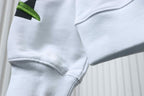 Off-White off-white hoodie pocket and sleeve hem detail with green leaf patch.
