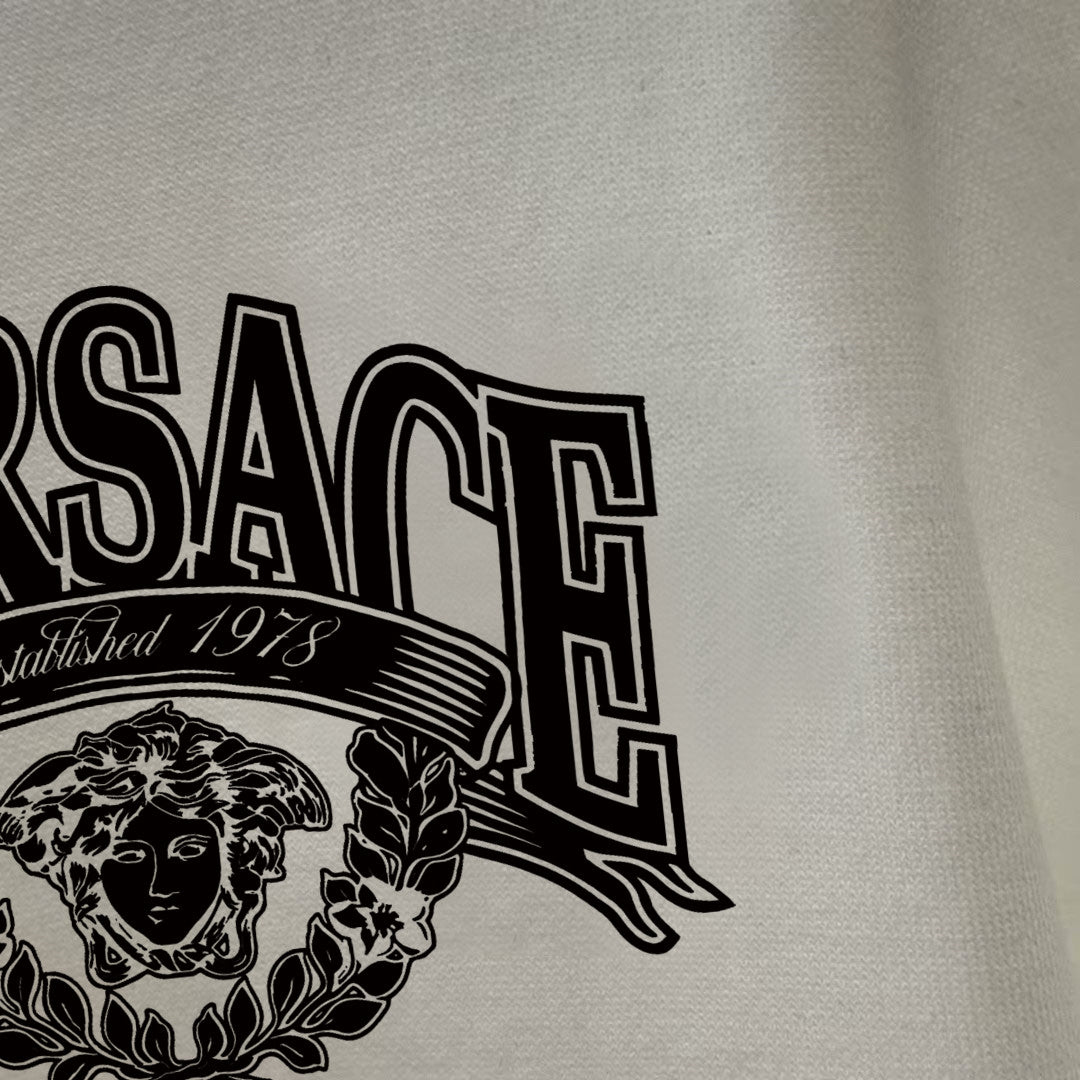 Off-white/cream long-sleeve T-shirt close-up of logo lettering and crest