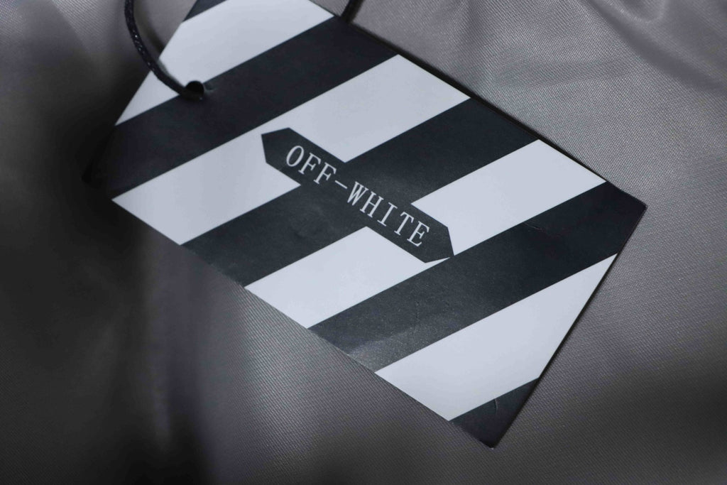 OFF-WHITE branded tag attached to a grey jacket
