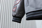 Off White grey jacket sleeve with black faux leather cuff and red logo patch