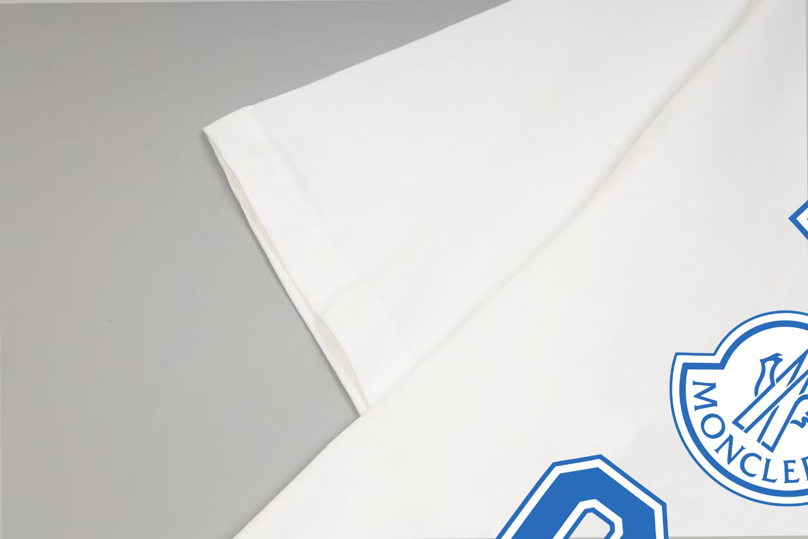 White T-shirt sleeve with blue patch graphic detail