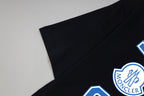 Black T-shirt with blue Moncler crest detail near sleeve/shoulder