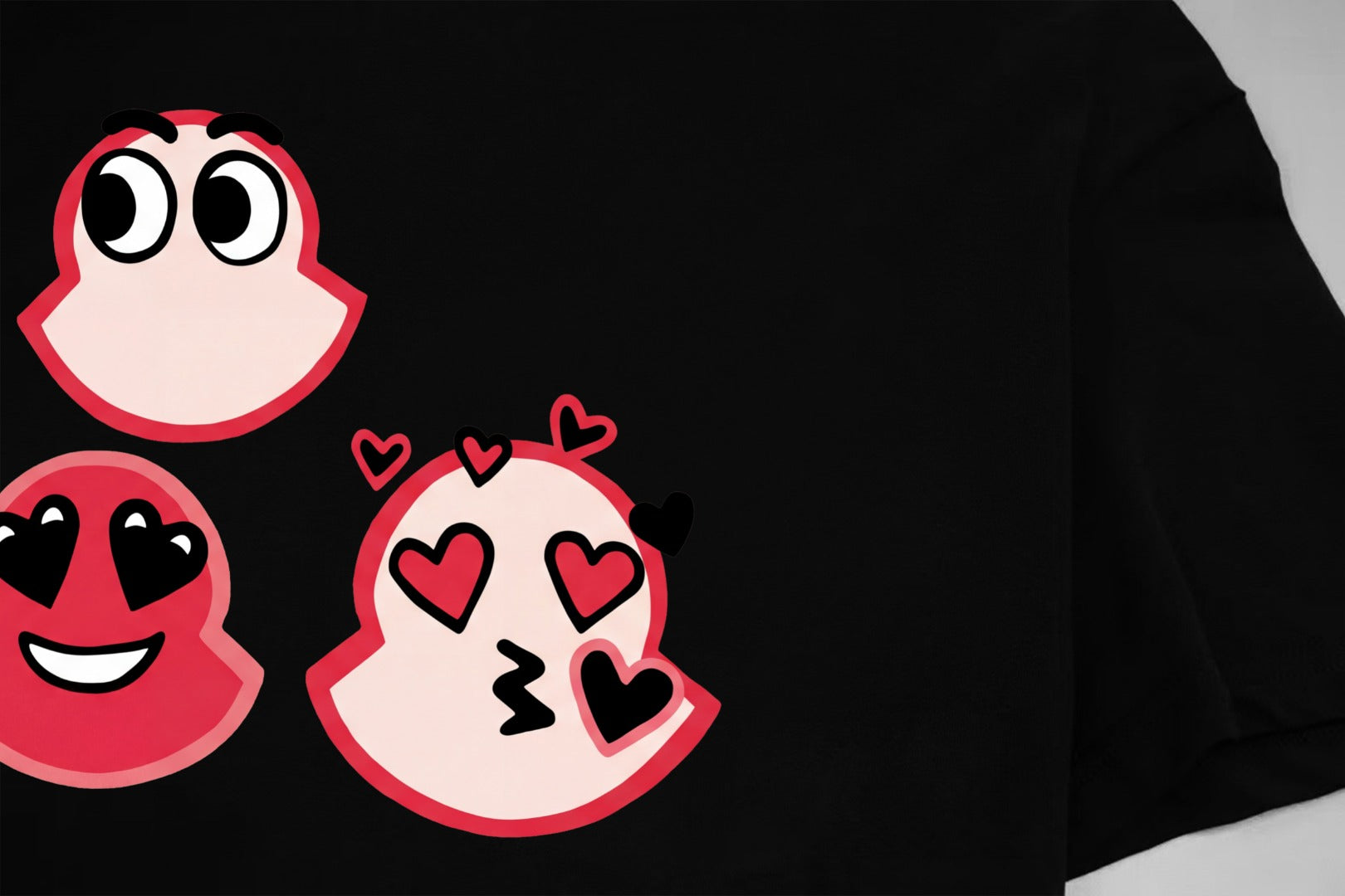 Black T-shirt with red cartoon faces and hearts graphic