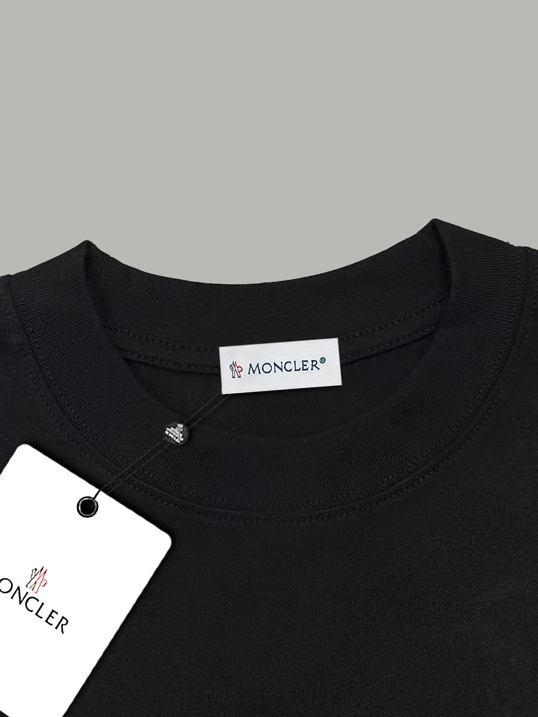 Black crewneck T-shirt neckline with Moncler label and snap stud