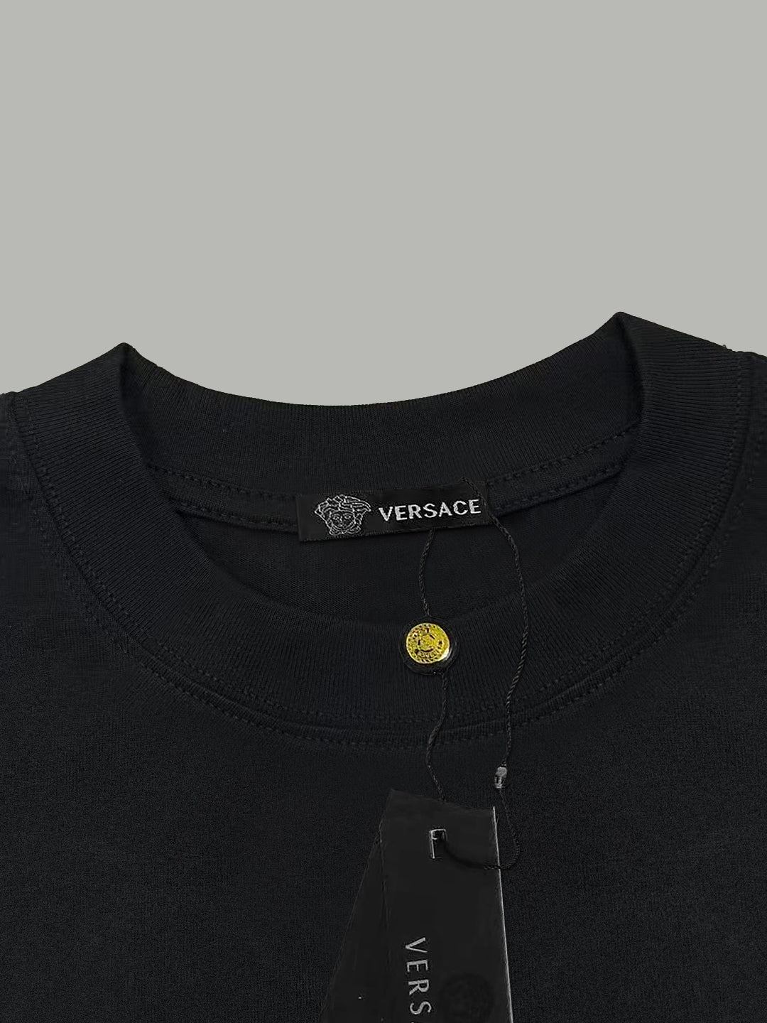 Black crewneck T-shirt neckline with Versace label and attached hang tag