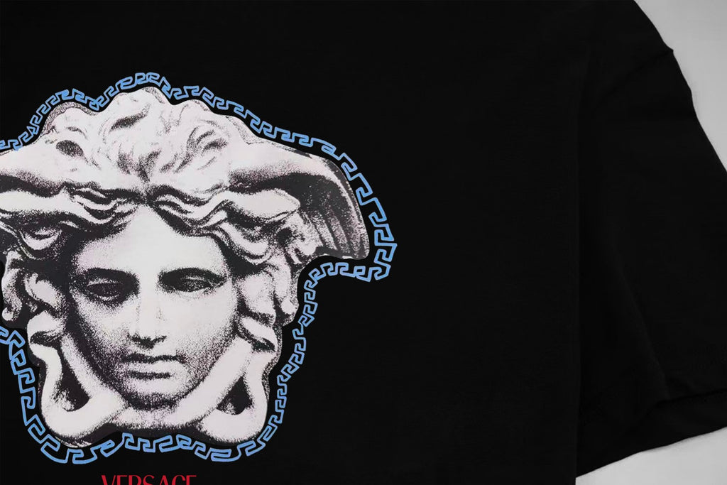 Black T-shirt chest graphic of Medusa in white with blue Greek key border