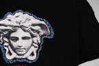 Black T-shirt chest graphic of Medusa in white with blue Greek key border