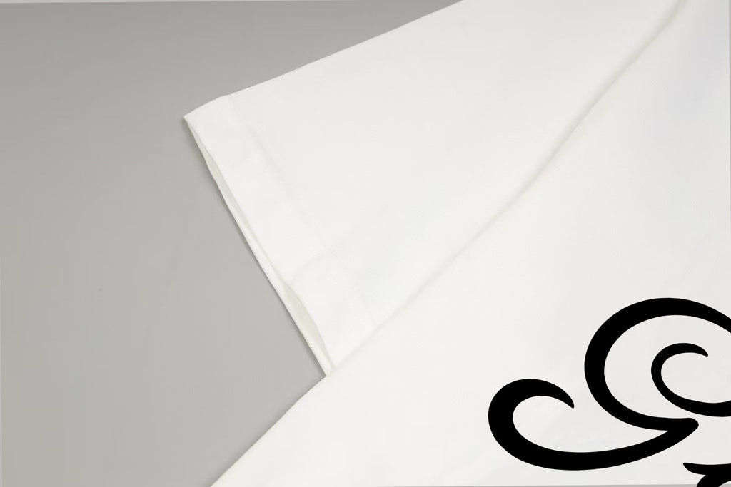 White T-shirt sleeve and hem close-up with partial black logo print