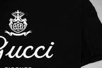 Black Gucci short-sleeve T-shirt close-up of crest and white “Gucci” script
