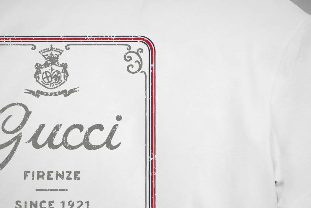 White Gucci T-shirt front logo close-up with red border and gray 'Gucci' print