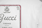White Gucci T-shirt front logo close-up with red border and gray 'Gucci' print